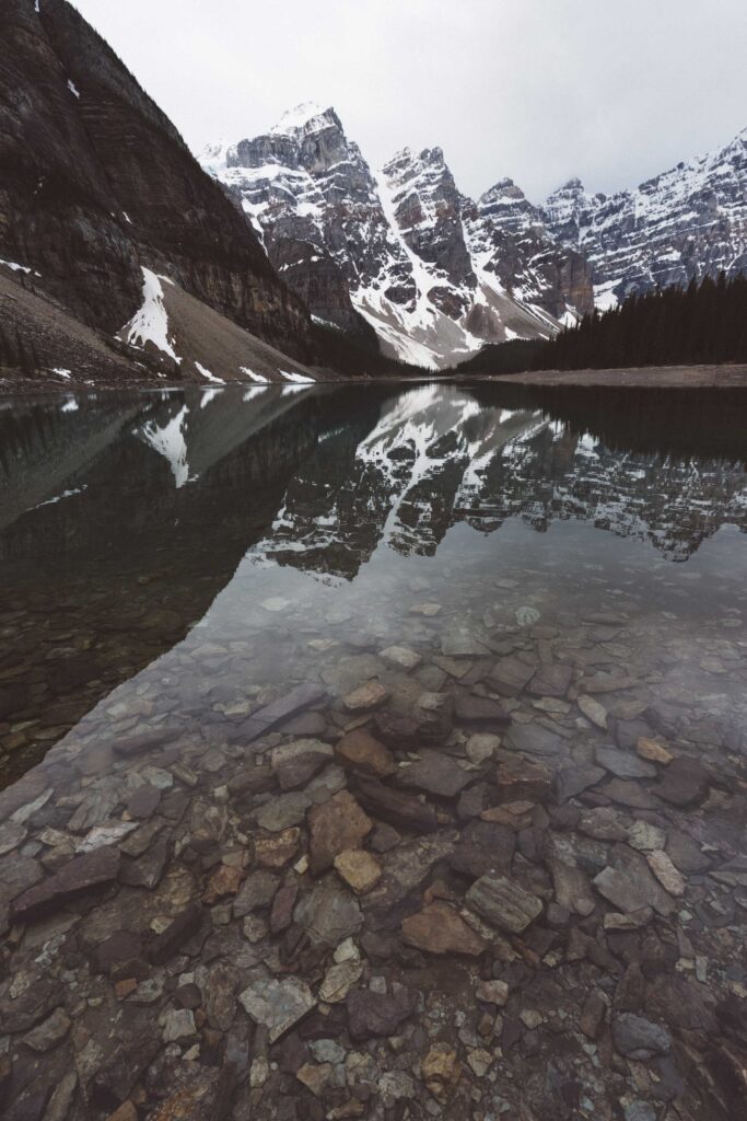 snow covered mountain near body of water during daytime