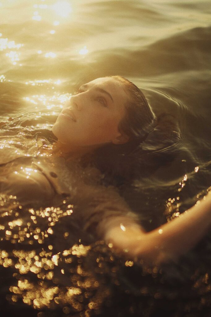 woman in water with white flowers