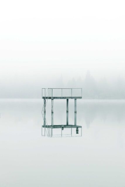 photography gray metal tower near body of water during daytime