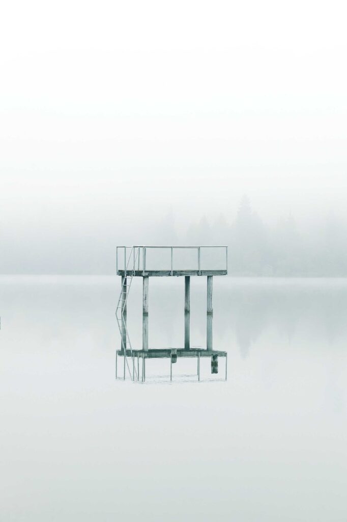 photography gray metal tower near body of water during daytime