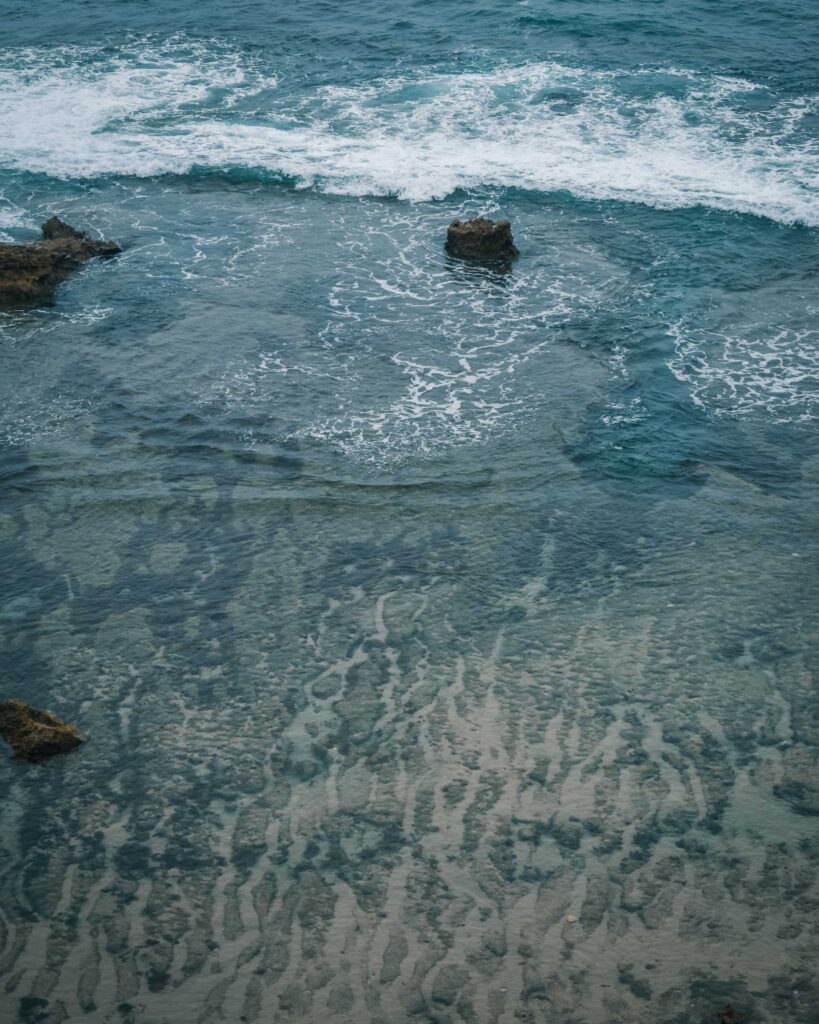 brown rock formation on body of water during daytime