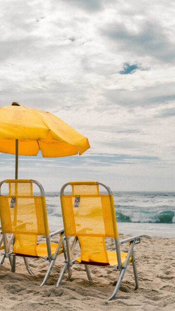 yellow and white patio umbrella on beach during daytime