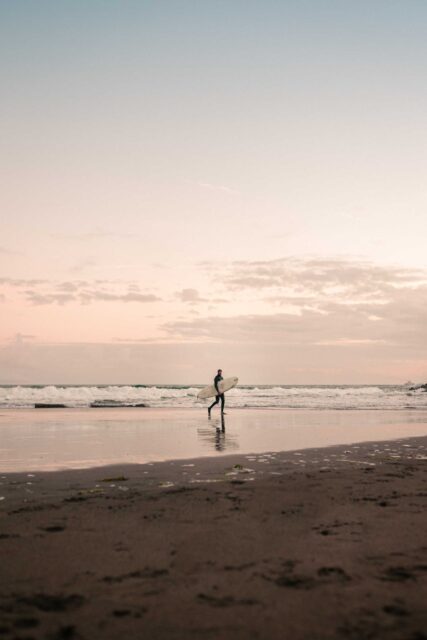 silhouette of man walking on beach during daytime