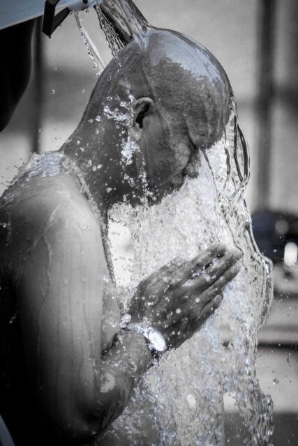 grayscale photo of man bathing on water
