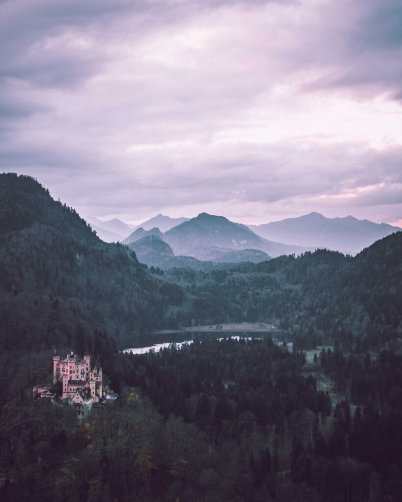 castle on mountain near body of water