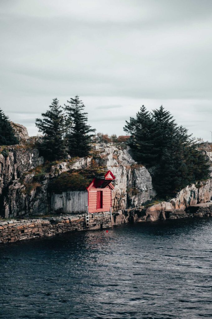 red and white house near body of water during daytime